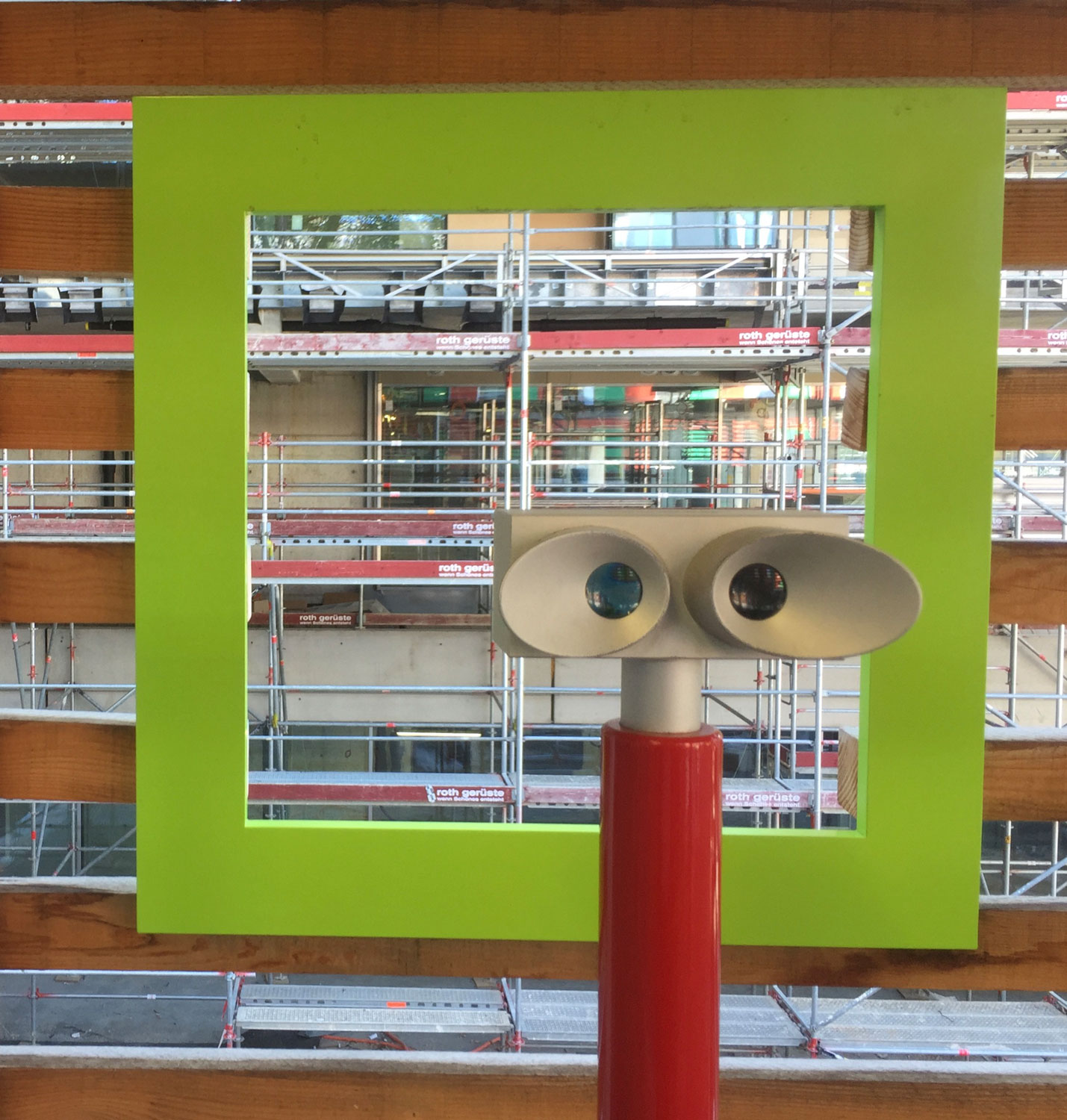 Ein Okular auf ein im Bau befindliches Gebäude gerichtet