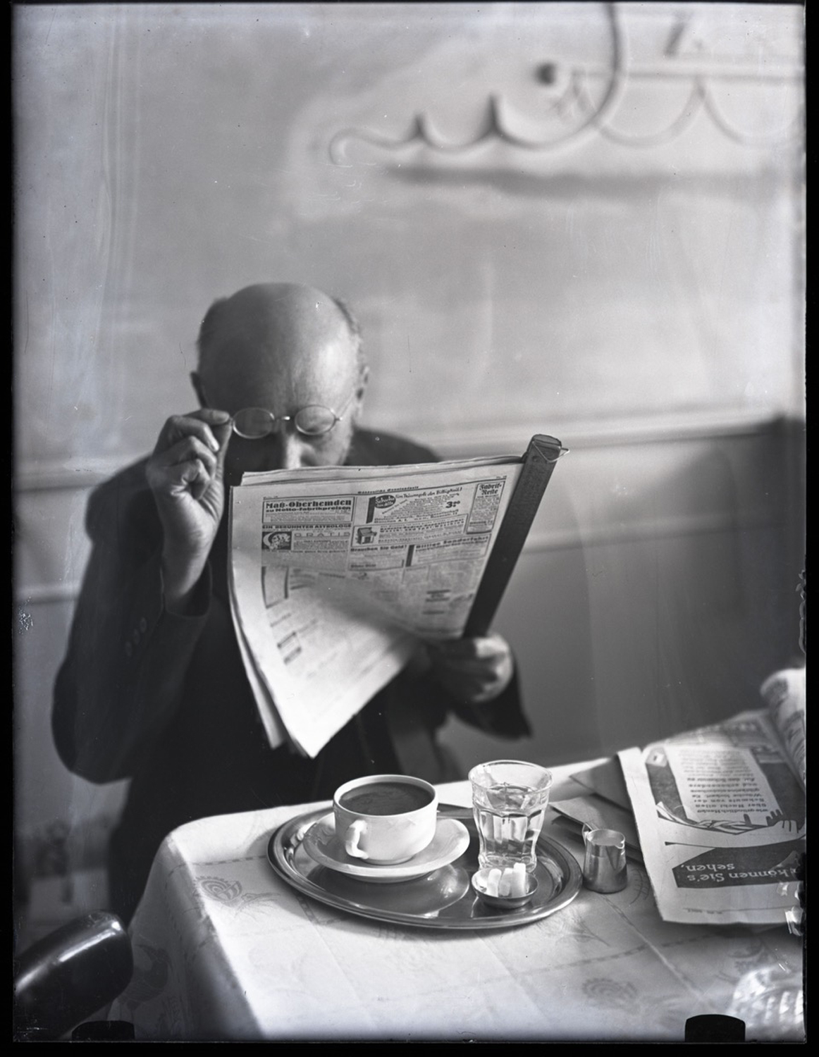Zeitungsleser im Café. Foto von Julius Guggenheimer